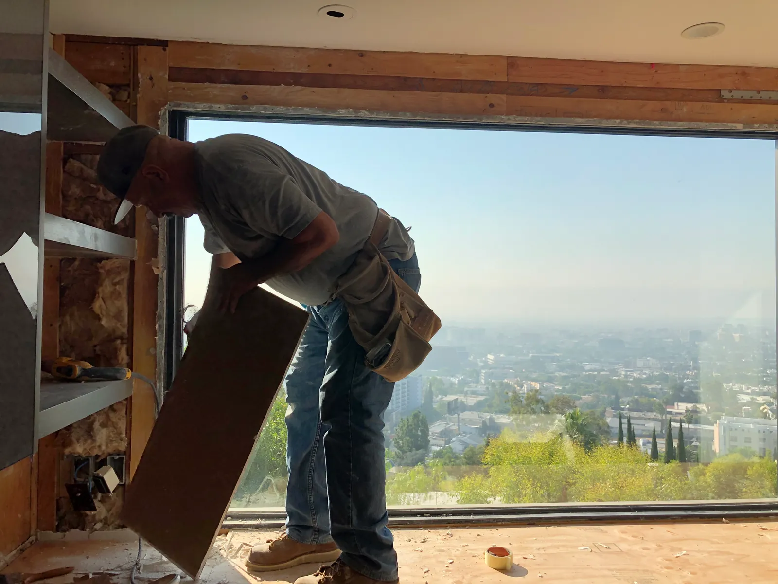 Installer carrying board past a full-width view window