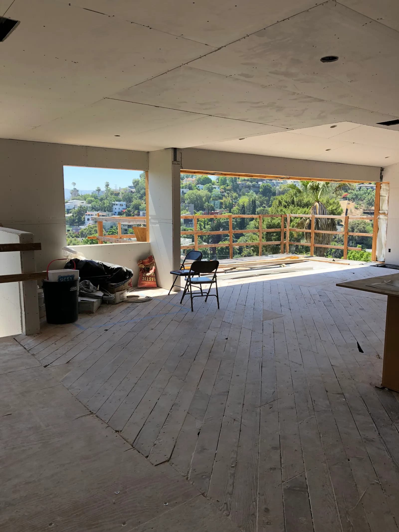 Boarded room with full-width window walls overlooking the hills