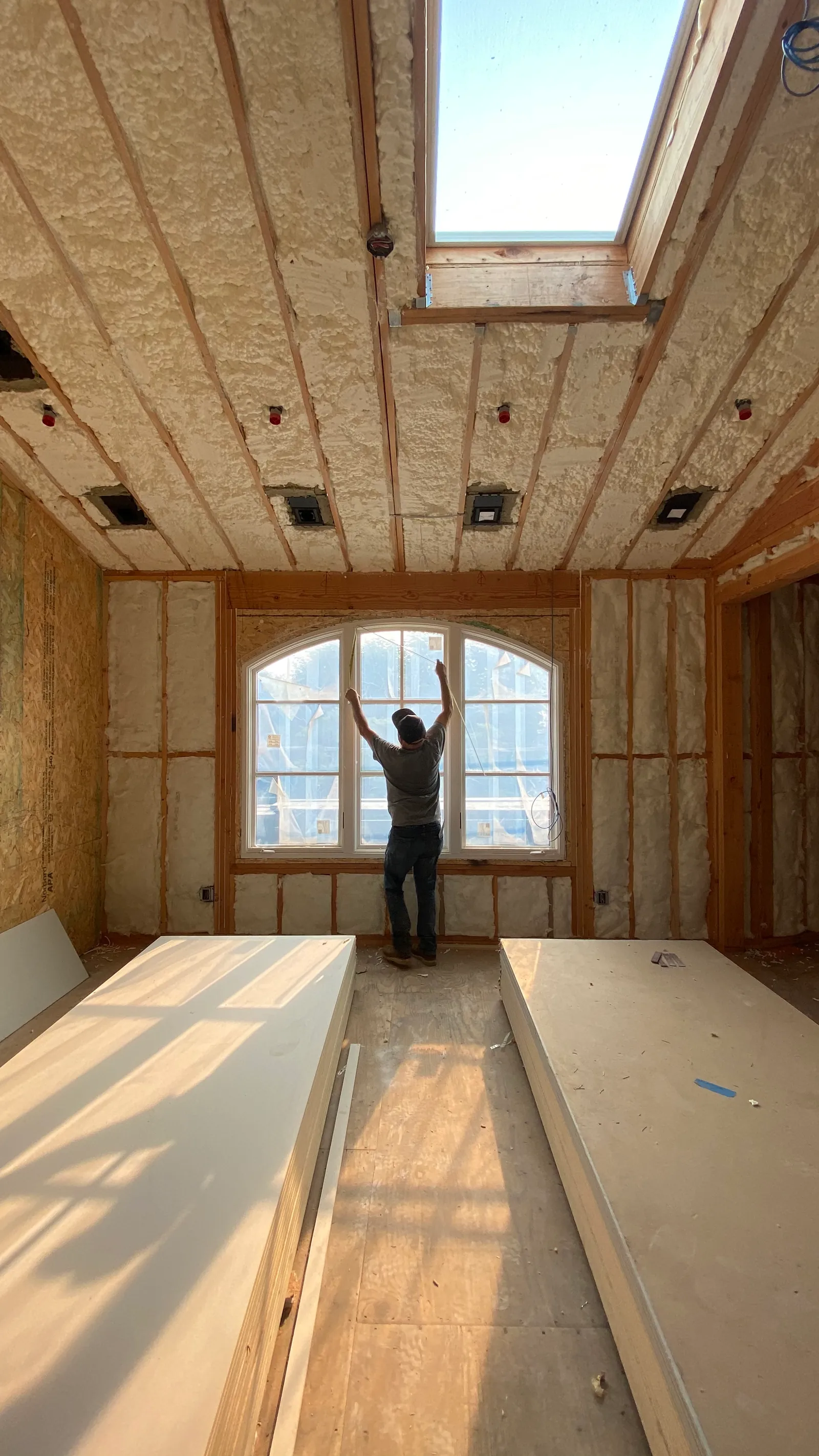 Installer working an arched window opening