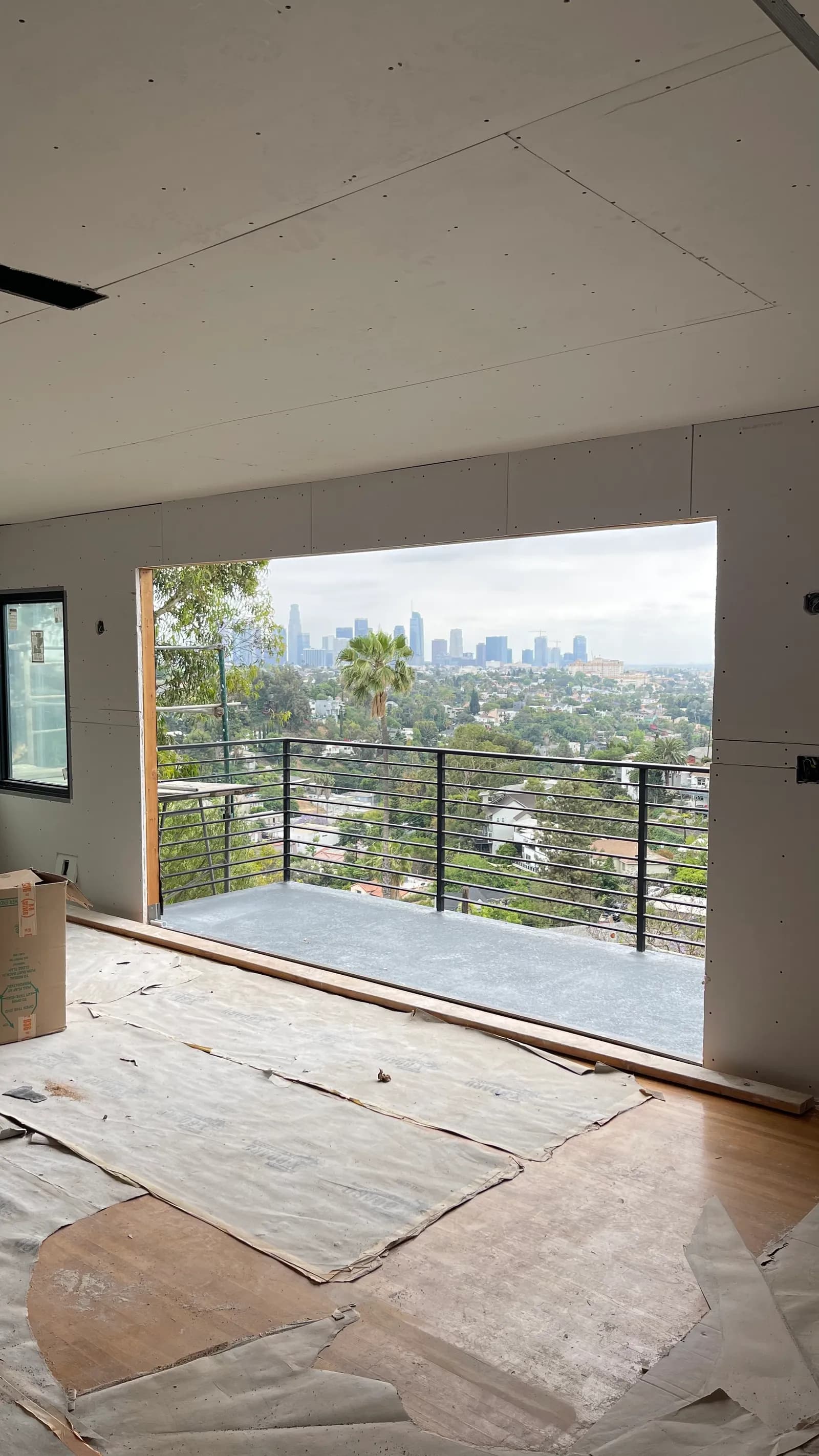 Living space hung with board, city skyline through the opening